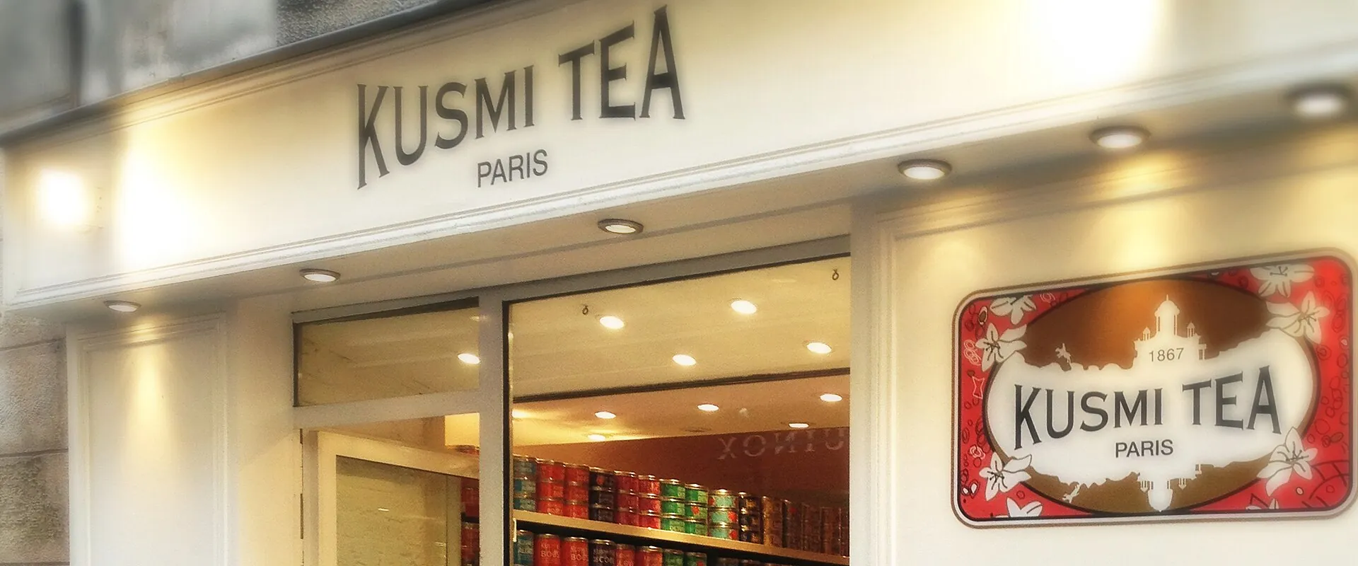 The Kusmi Tea boutique at 56 rue des Rosiers, in the Marais: the KUSMI TEA PARIS sign, the red 1867 plaque and shelves of coloured tins.