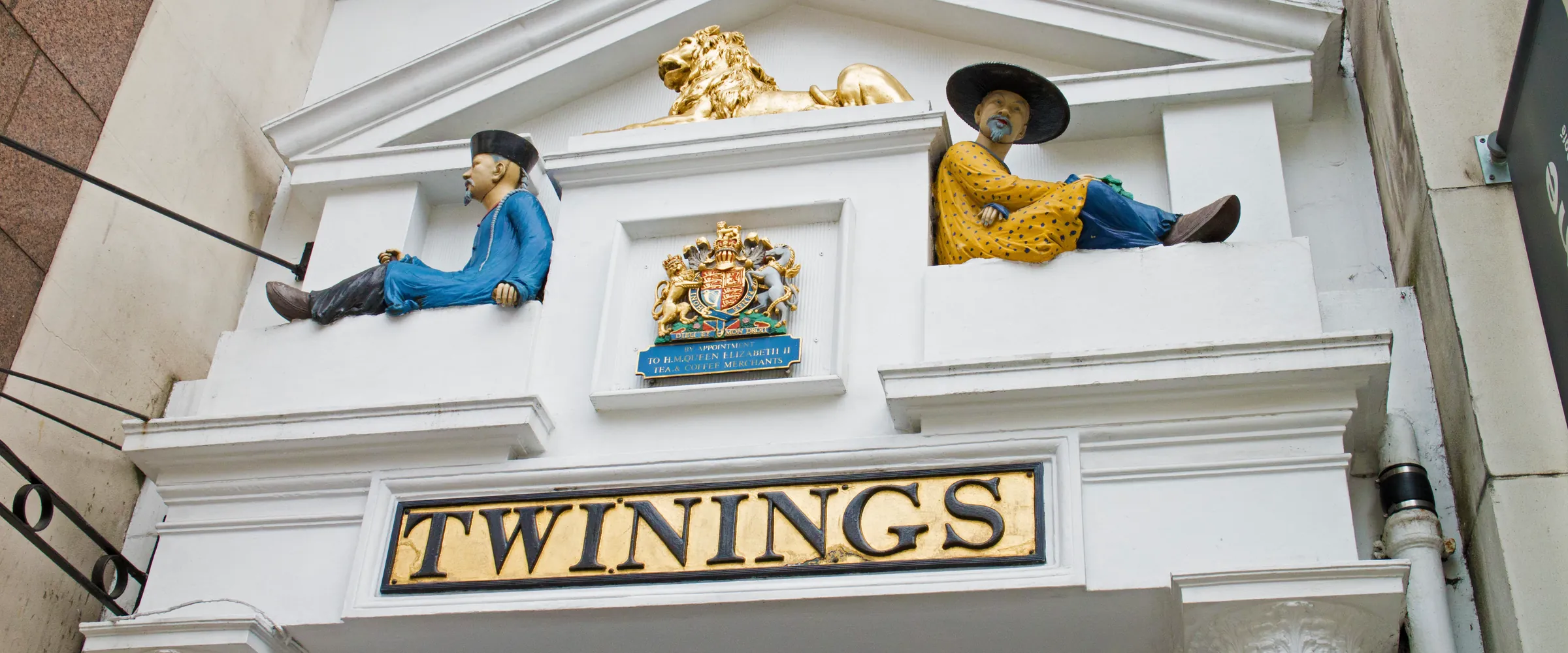 The Twinings doorway at 216 Strand: a golden lion, two seated Chinese figures, the royal coat of arms and the gold TWININGS sign.
