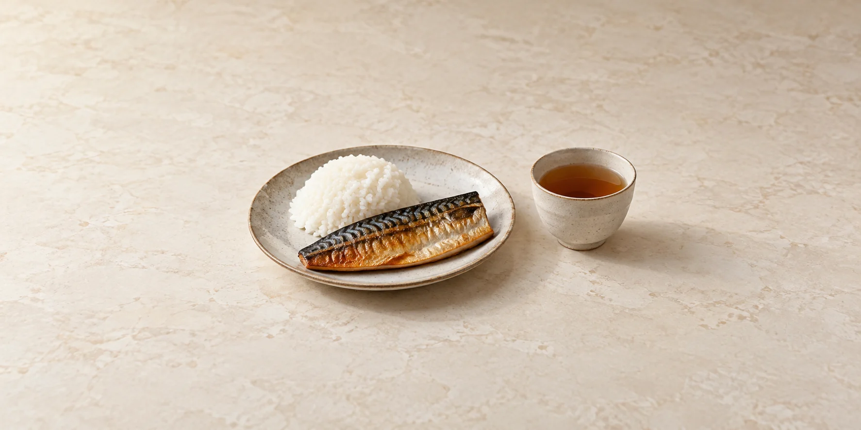 Grilled mackerel and steamed rice beside roasted barley tea.
